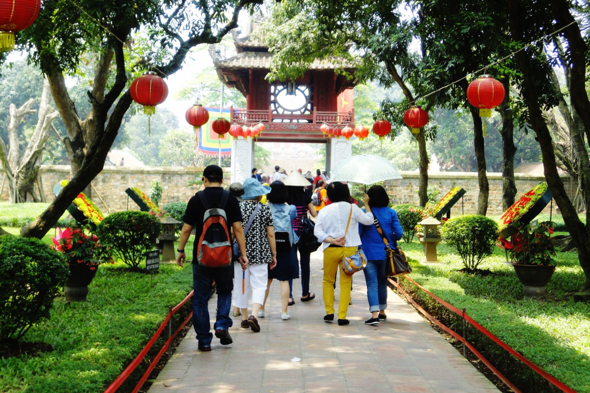 Visitors walking through the tranquil courtyards of Temple of Literature Hanoi, exploring historical architecture